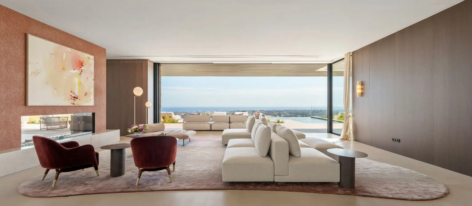A luxury Mediterranean living room with floor-to-ceiling windows opening onto a terrace, pool, and panoramic sea views — representing Luumare Estate's curated property offerings